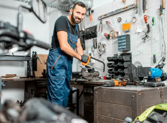 Mechanic smiling, working in workshop.